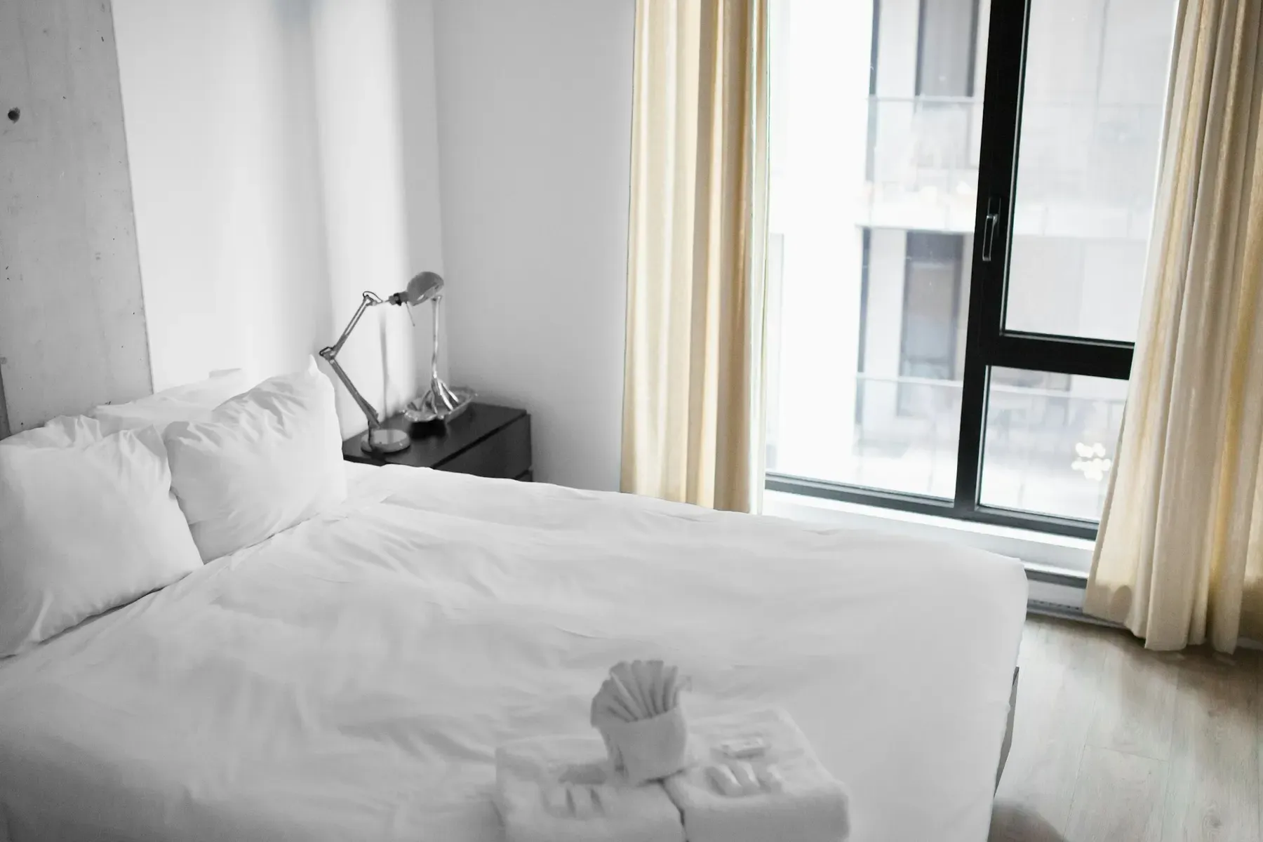 Opgemaakt bed met wit linnen